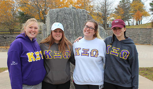 KXO Sorority poses in front of the Campus Plaza rock.