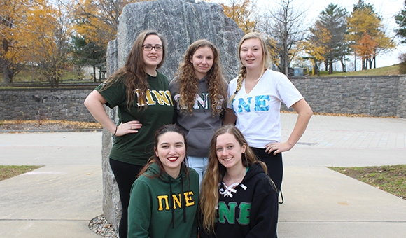 PNE Sorority poses in front of the Campus Plaza rock.