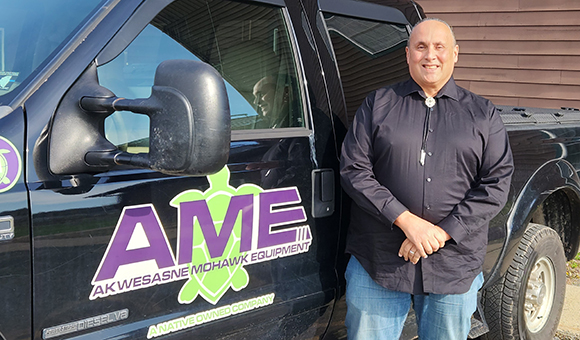 Andre White stands next to his AME branded black truck.