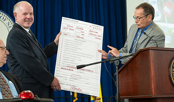 Brian Kurish is presented with a giant mock-parking ticket from master of ceremonies Randy Sieminski.