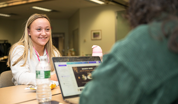 Carly LaBow works with a colleague on a laptop to develop their idea at Launch Day.