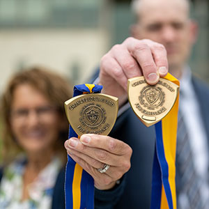 Shelly Thompson and Travis Smith hold up their Chancellor's Award medallions.