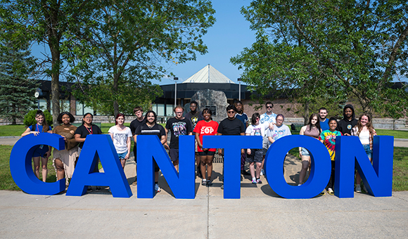 EOP students stand behind giant Canton letters outside Miller Campus Center