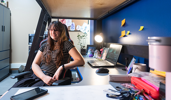 Lexa Leach sits at a desk in her new Esports Wing room.