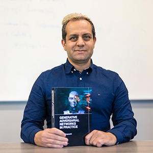 Mehdi Ghayoumi holds his new book 