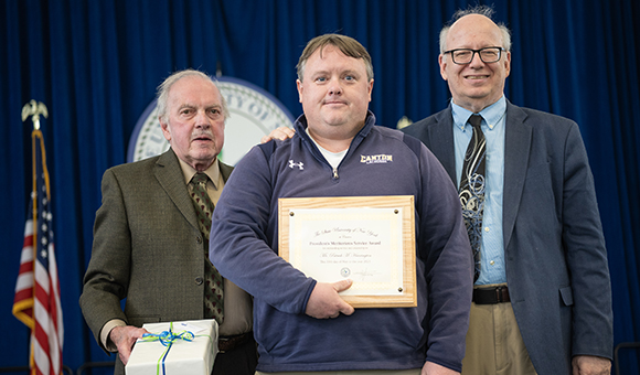 Patrick Harrington accepts the Presidential Meritorious Service Award from Ronald O'Neill and President Szafran.