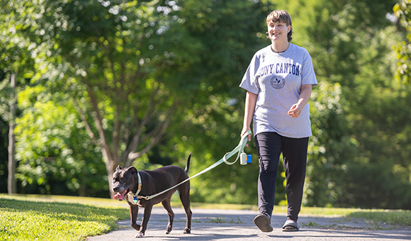 Wolf Dingman takes their dog, Selene, on a campus walk.