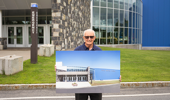 Terry Martin holds a rendering of the future Terry Martin Arena.