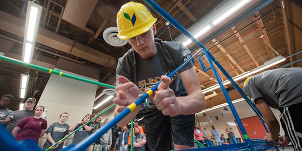 A student assembles a steel bridge.