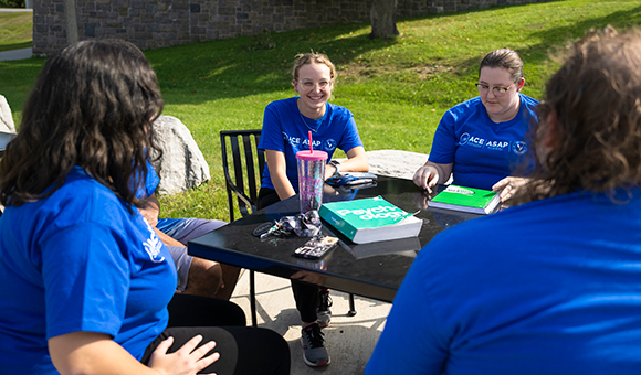 ASAP and ACE students sit at a table outside Dana Hall.