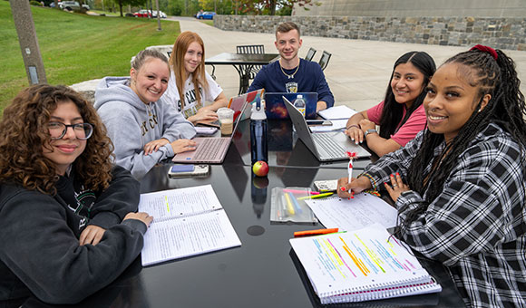 A group of students study outside Dana Hall.