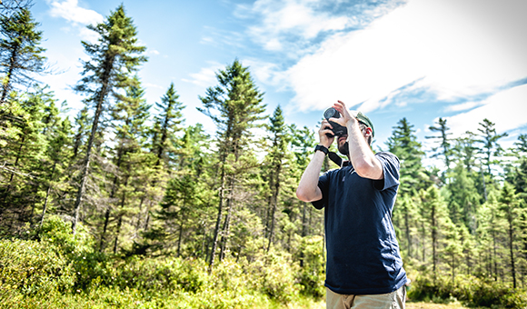 A student photographs the scenery in the Adirondacks.