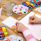 A student surrounded by paints and mixing wheels begins painting