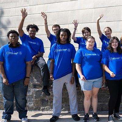 ASAP|ACE students in blue shirts wave outside Dana Hall.