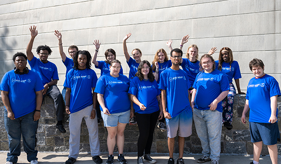 ASAP|ACE students in blue shirts wave outside Dana Hall.