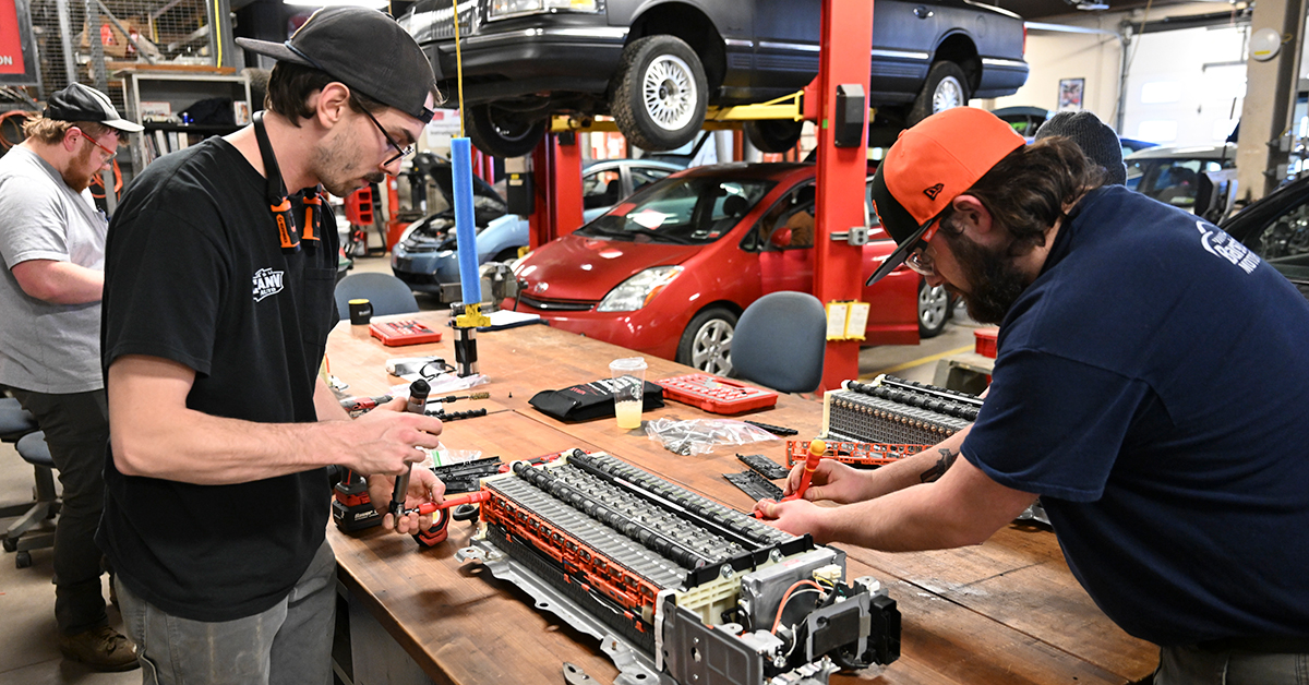 Two students assemble a battery bank from a Toyota Prius in the Automotive Lab.