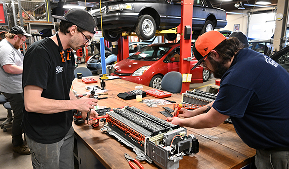 Two students assemble a battery bank from a Toyota Prius in the Automotive Lab.