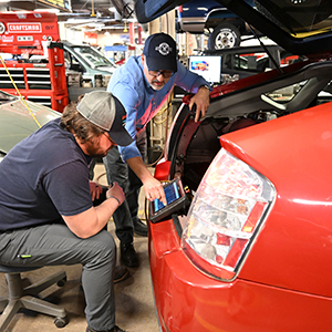 Associate Professor Brandon Baldwin works with a student to scan a Toyota Prius.