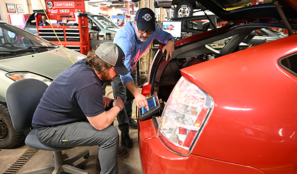 Associate Professor Brandon Baldwin works with a student to scan a Toyota Prius.