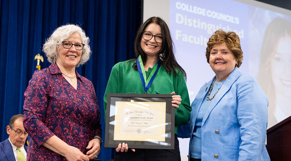 College Council members Kathy Dodge and Jenn Stevenson award Dr. Barat Wolfe.