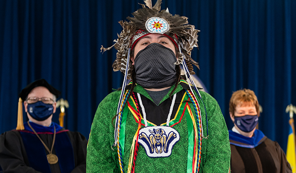 Brayden White stands on stage for a photo with SUNY Canton President Zvi Szafran and Provost Peggy DeCooke