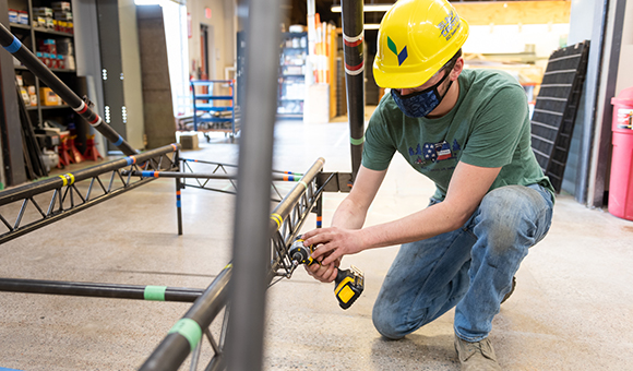 Jaden Caldwell attaches a bolt to the steel bridge.