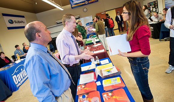 Kevin LaJuett and Jeffrey Carpenter speak with Barandy Nurdinova at the college’s career fair.