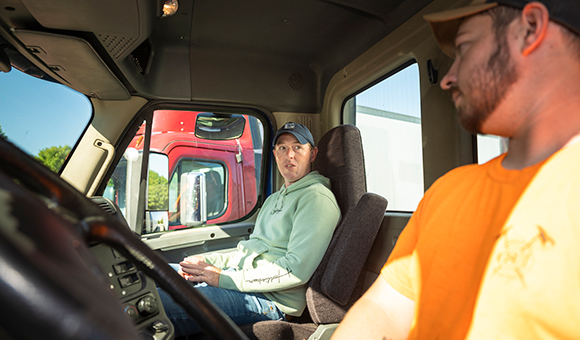 Ryan Harrigan and a student sit in the cab of SUNY Canton's new CDL training truck.