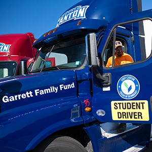 A student sits in the new blue truck donated by the Garrett Family Fund.