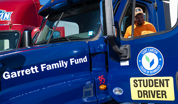 A student sits in the new blue truck donated by the Garrett Family Fund.