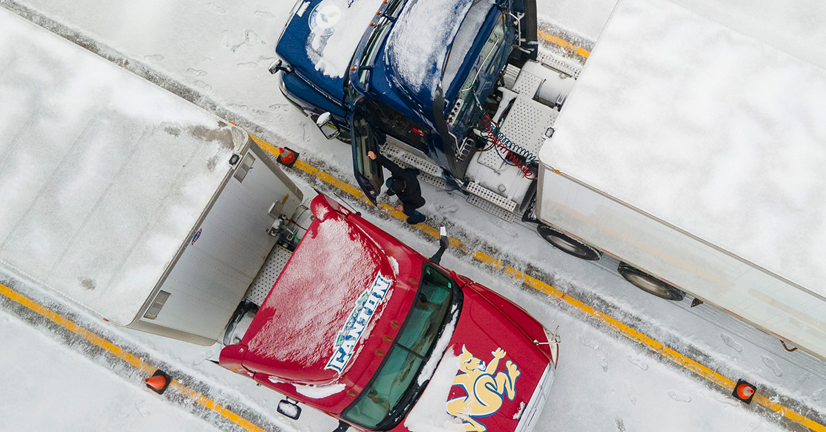 An overhead view of a red and blue truck parked diagonally in the snow.