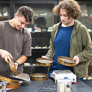 Two students sift through sediment in the water filtration lab.