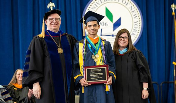 Outstanding Baccalaureate Graduate winner Muhammad Shabbir accepts his award with President Szafran and Vice President Courtney Bish.