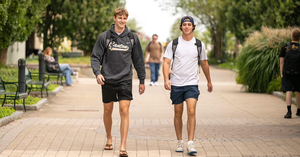 Two students traverse the Roselle Academic Concourse on their way to class.