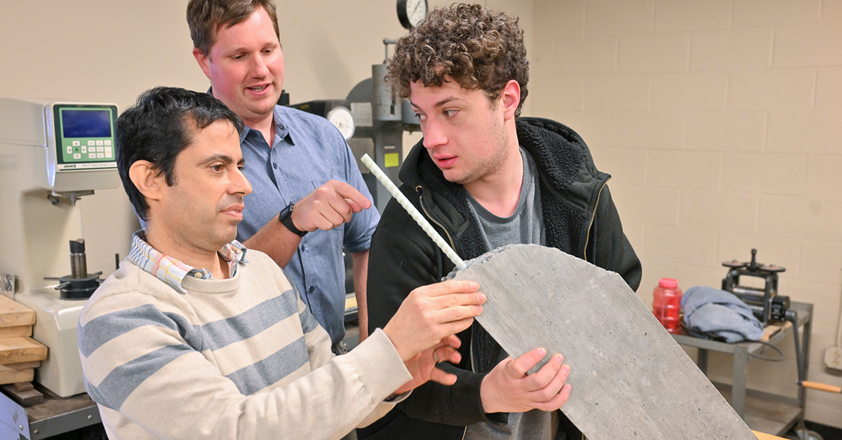 Saied Haji Ghasemali, Brett Miller, and Seth Thomas inspect a concrete sample.