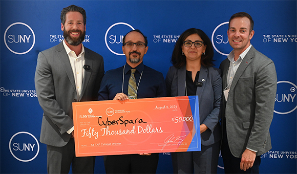 Cambia Ghazinour accepts a check from the SUNY Summer Startup School on behalf of CyberSpara.