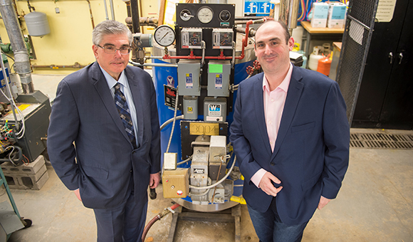 Michael Berman and David Sher stand next to HVAC equipment.