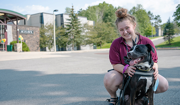 A student holds her dog outside of Mohawk Hall.