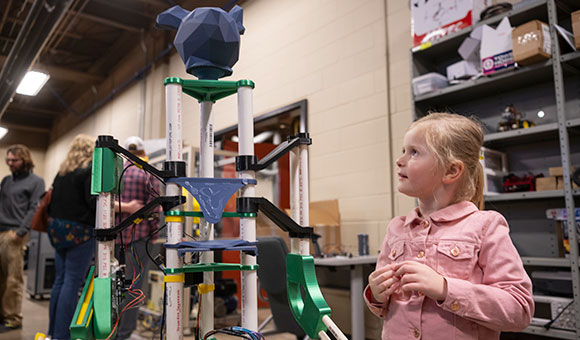 A student looks at a model robot during the Engineer's Week Open House.