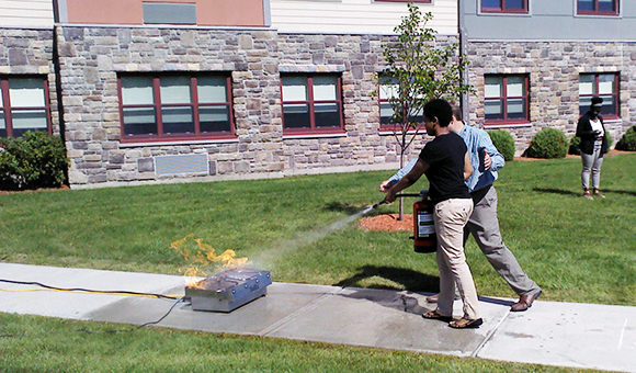 Students extinguish a fire outside Kennedy Hall