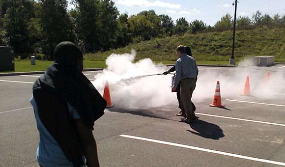 Students practice extinguishing in a parking lot.