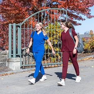 Two nursing students walk down the Wicks Hall ramp on a beautiful fall day.