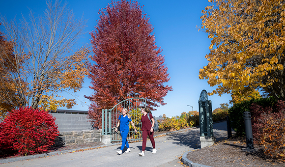 Two nursing students walk down the Wicks Hall ramp on a beautiful fall day.