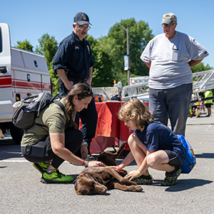 Students pet a police dog at the First Responders Fair.