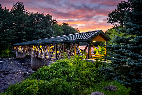 Vibrant pink and purple skies above the SUNY Canton footbridges at sunset.