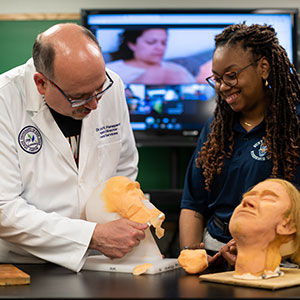 Dr. Penepent demos face modeling as a student looks on.