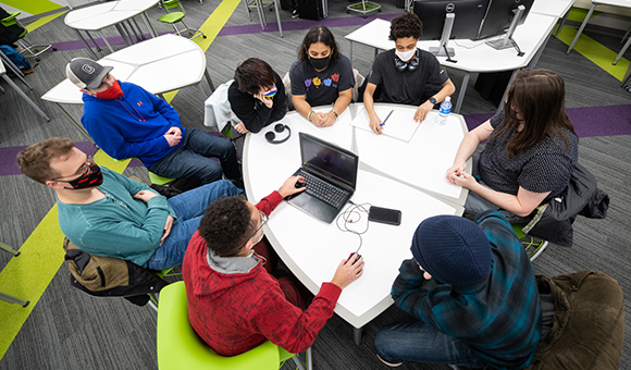A group of game design students conduct a team production meeting.