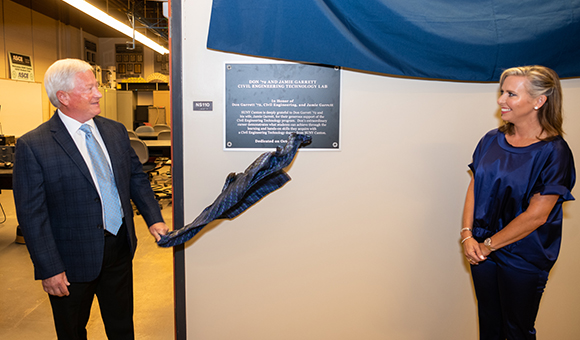 Don and Jamie Garrett pull down a banner to reveal a plaque bearing their name.