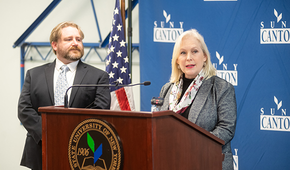 Senator Kirsten Gillibrand speaks while Ben Dixon looks on.