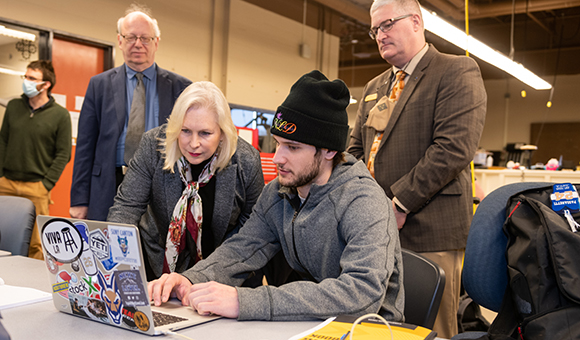 A student shows Senator Kirsten Gillibrand his work during a campus visit.